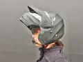 Profilo di una persona con casco da moto modulare nero, visiera sollevata e microfono. Guida sicura: come scegliere casco moto.