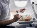 Pasażer je posiłek na pokładzie samolotu. Zastanawiasz się, czy można przewozić jedzenie w bagażu rejestrowanym Ryanair?