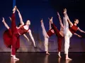 Tancerze wykonują dynamiczny jazz dance, unosząc nogi w powietrze.