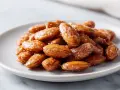 Ein Teller mit glasierten, gebrannten Mandeln, perfekt zubereitet im Airfryer.