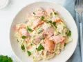 Pasta cremosa con trozos de salmón rosado y perejil fresco. Un plato delicioso y nutritivo.