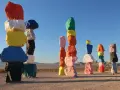 Les **seven magic mountains** illuminent le désert. Des rochers colorés empilés créent une œuvre d'art vibrante sous un ciel bleu.