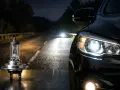 En strålkastare, en "night breaker", lyser upp en mörk väg. Bilens strålkastare lyser starkt.
