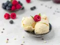 Cremiges Vanilleeis, garniert mit einer Himbeere. Perfekt, um eis ohne zucker selber machen zu lernen.