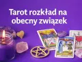 Tarot rozkład na obecny związek. Świeca, kryształy i karty tarota, w tym Trzy Miecze, tworzą mistyczną atmosferę.
