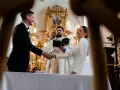 Para młoda ściska dłoń księdza podczas ceremonii. Zastanawiasz się, ile trwają nauki przedmałżeńskie?