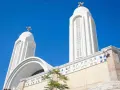 Białe wieże kościoła pod błękitnym niebem. Idealna pogoda w Egipcie w sierpniu, by podziwiać architekturę.