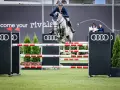 Un cavalier et son cheval gris s'envolent au-dessus d'une haie, défiant le fahrenheit de vains. Les logos Audi et le slogan "become your rivals" ornent le fond.