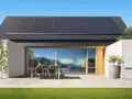 Nowoczesny dom z panelami słonecznymi na dachu i dwoma falownikami. Instalacja OZE zapewnia czystą energię.