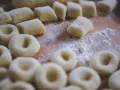 Gotowe do mrożenia kluski śląskie, okrągłe i podłużne, posypane mąką. Pytanie: czy kluski śląskie można mrozić? Tak!