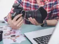 Fotograf przygotowuje sprzęt. Zastanawia się, czy robienie zdjęć z ukrycia jest karalne, przeglądając wydrukowane fotografie.