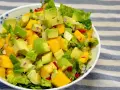 Orzeźwiająca sałatka z awokado, mango i czerwoną cebulą, polana lekkim sosem mango do sałatki.