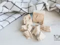 Kostki świeżych drożdży, gotowe do pieczenia puszystego ciasta drożdżowego. Obok leży biały ręcznik w kratkę.