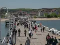 Spacer po molo w Sopocie, gdzie tłumy ludzi korzystają z uroków Bałtyku. To idealne miejsce na relaks i odkrywanie gdańskich atrakcji dla dorosłych.