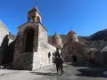 Kamienny klasztor w Armenii, świadectwo bogatej historii i religii. Dwóch mężczyzn spaceruje po dziedzińcu.