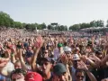 Foule en délire à un concert, mains levées. Certains portent un bouchon oreille sifflement pour se protéger du bruit assourdissant.