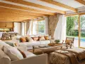 Salones de casas modernas con techos de madera, sofás blancos y vistas a una piscina.