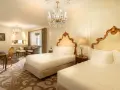 Luksusowy pokój z dwoma łóżkami w hotelu Plaza w Nowym Jorku, z kryształowym żyrandolem i złotymi zdobieniami. Zastanawiasz się, ile kosztuje noc w hotelu Plaza w Nowym Jorku?