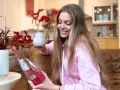 Uśmiechnięta kobieta trzyma kubek i paczkę yerba mate, przygotowując się do parzenia.