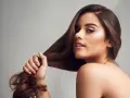 Frau mit langen, braunen Haaren, die sich fragt, wie sie ihre **Haare schneller wachsen lassen Hausmittel** anwenden kann.