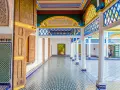 Kolorowy dziedziniec w Maroko, Marrakesz. Wzory geometryczne na ścianach i podłodze, zdobione drzwi i kolorowy sufit.