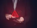 Czerwony trójkąt z wykrzyknikiem nad tabletem, symbolizujący groźbę karalną w cyfrowym świecie.