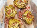 Deliciosas alcachofas al horno, doradas y rellenas de trocitos de jamón, listas para disfrutar.
