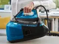 Mano che solleva un ferro da stiro moderno blu e nero, con serbatoio trasparente e tecnologia Silence.