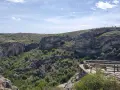 Impresionante vista del **barranco del Río Dulce**, con sus paredes rocosas, vegetación exuberante y un mirador de madera.