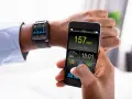 Mężczyzna sprawdza na smartfonie i zegarku dane treningowe: tętno 157 bpm, dystans 2.31 km. Zegarek mierzący ciśnienie pokazuje wykresy.