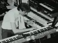 Mann spielt auf mehreren Synthesizern, die typische Klänge der 80er Jahre erzeugen.