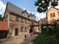 Zamek Książ i jego okolice to jedne z najpiękniejszych wałbrzych atrakcje. Drewniany most łączy zabytkowe budynki, a dzieci zwiedzają teren.
