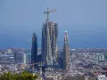 La Sagrada Familia, en plein temps de construction, domine le paysage urbain de Barcelone. Des grues témoignent de l'évolution de ce chef-d'œuvre architectural.
