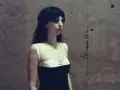 Stella Rose Gahan w czarnej sukience z białym gorsetem, stoi przy betonowej ścianie.