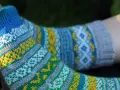 Två par stickade sockor med färgglatt sticka mönster med två färger i blått, gult, grönt och vitt.