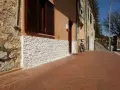 Una parete umida è stata rivestita con pietre bianche, migliorando l'estetica e la protezione dell'edificio.