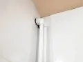 Białe osłonki na rury co, zamontowane przy białych kafelkach, tworzą estetyczne wykończenie instalacji.