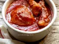 Un saporito ragù napoletano in una ciotola bianca, con pezzi di carne succulenta immersi nel sugo rosso intenso.