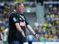 Trener Nikolaj Jacobsen w czarnej koszulce z logo DKB, gestykuluje na tle trybun pełnych kibiców.