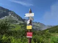 Droga do Morskiego Oka i Zawratu. W tle góry, a na pierwszym planie tabliczki szlaków. W oddali widać fragment szlaku na **Świstową Czubę**.