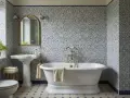 Bagno con piastrelle blu e bianche, vasca freestanding e lavabo a colonna. Un esempio per capire quanto costa piastrellare un bagno.