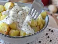 Ziemniaki w kremowym sosie z pieprzem, inspirowane przepisem Cacio e Pepe. Widok z bliska na widelec nabijający ziemniaka.