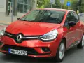 Czerwony Renault Clio 3 1.2 benzyna w ruchu miejskim. Kierowca w okularach przeciwsłonecznych.