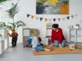 Bambini giocano in una stanza colorata, con scaffali pieni di giochi. Ottime idee stanza giochi bambini per un ambiente stimolante.