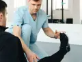Fizjoterapeuta sportowy pomaga pacjentowi w ćwiczeniach. Zastanawiasz się, ile zarabia fizjoterapeuta sportowy?