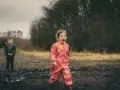 Ein 4-jähriges Kind schreit hysterisch in einem Matschfeld. Ein Junge steht im Hintergrund.