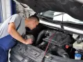 Mechanik bada silnik, szukając przyczyn opóźnionej reakcji na gaz diesel.