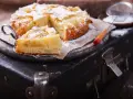 Pyszne, domowe ciasto z jabłkami, posypane cukrem pudrem, czeka na spróbowanie. Idealne na deser!