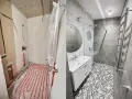 Łazienka przed i po remoncie. Widoczna instalacja wodna i ogrzewanie podłogowe, a potem nowoczesna armatura, prysznic i umywalka.