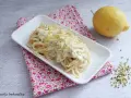 Spaghetti al limone cremosi, un piatto invitante con scorza di limone grattugiata e pistacchi tritati.